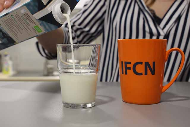 Image shows person pouring milk into a glass and an IFCN labeled mug next to it